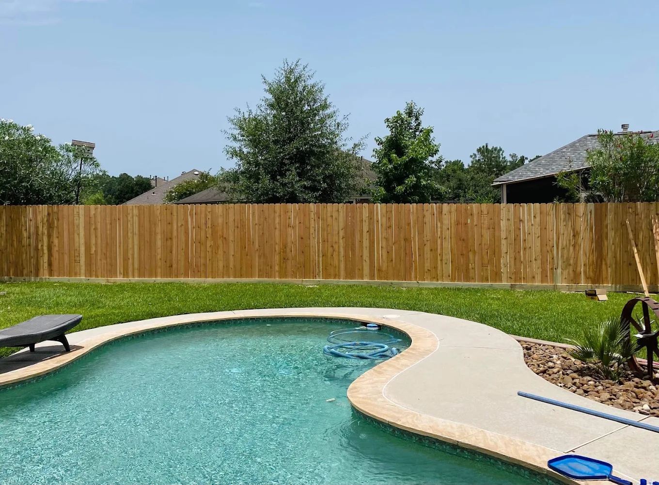 New cedar privacy fence enclosing a backyard swimming pool